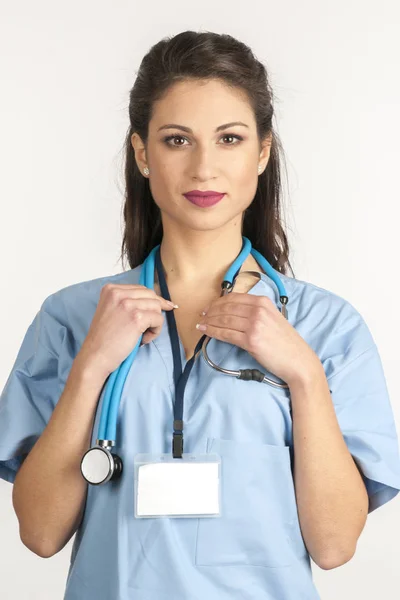 Female doctor in white surgical coat and stethoscope standing isolated on white background — Stock Photo, Image