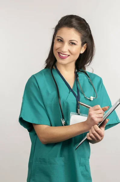 Médecin femme en manteau chirurgical blanc et stéthoscope debout isolé sur fond blanc — Photo