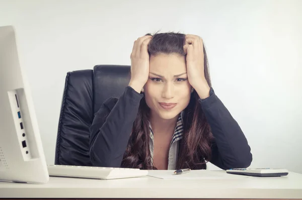 A young businesswoman is looking stressed as she works Royalty Free Stock Photos