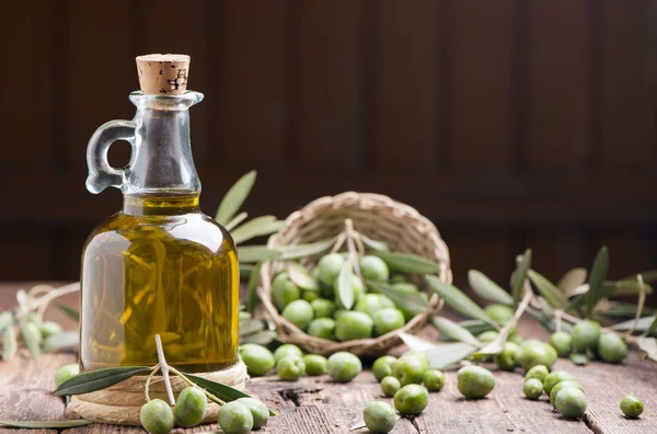 Huile d'olive et olives sur table rustique en bois — Photo