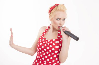 Komik bir pin-up izole portresi şarkı yıldız bir mikrofona konuşurken. Pop yıldız karaoke