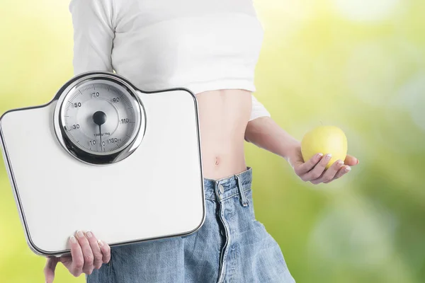 Νεαρή γυναίκα με μήλο και κλίμακες. Υγιεινή διατροφή και απώλεια βάρους — Φωτογραφία Αρχείου