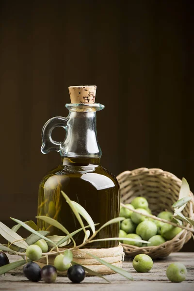 Huile d'olive et olives sur table rustique en bois — Photo