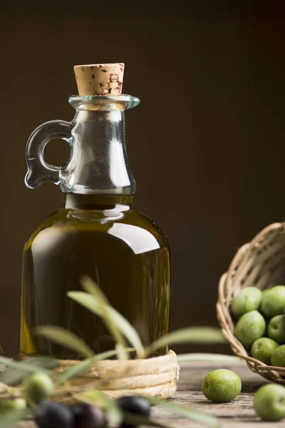 Huile d'olive et olives sur table rustique en bois — Photo