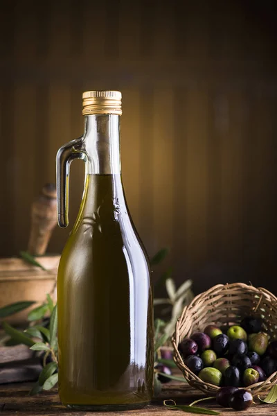 Aceite de oliva y aceitunas sobre mesa rústica de madera — Foto de Stock