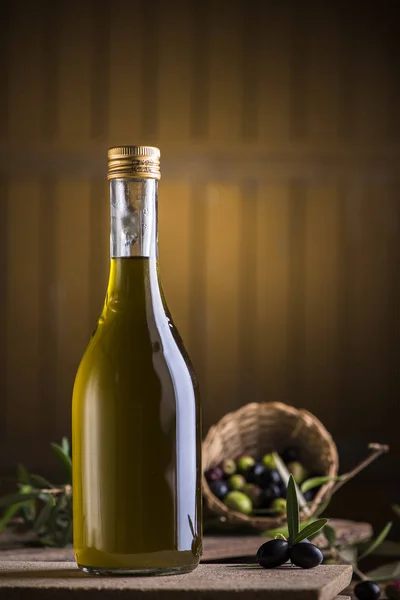 Aceite de oliva y aceitunas sobre mesa rústica de madera — Foto de Stock