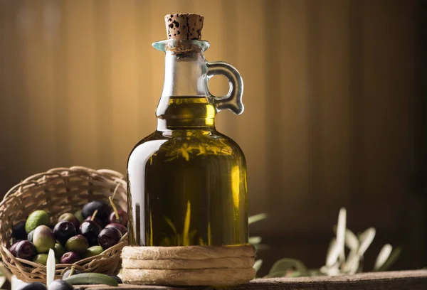 Aceite de oliva y aceitunas sobre mesa rústica de madera — Foto de Stock