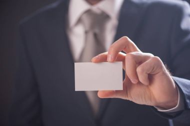 Adamın elini kartvizit izole koyu arka plan üzerinde gösterilen
