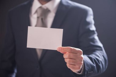 Adamın elini kartvizit izole koyu arka plan üzerinde gösterilen