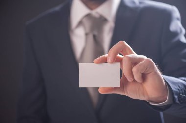Adamın elini kartvizit izole koyu arka plan üzerinde gösterilen