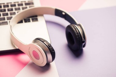 Kulaklık ve dizüstü bilgisayar taşımak. Online müzik konsepti.