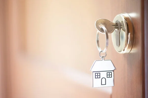 Uma chave em uma fechadura com forma de casa nele — Fotografia de Stock