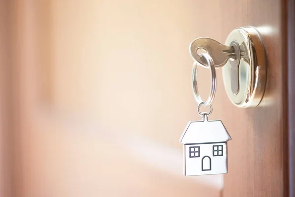 Una llave en una cerradura con forma de casa en ella — Foto de Stock