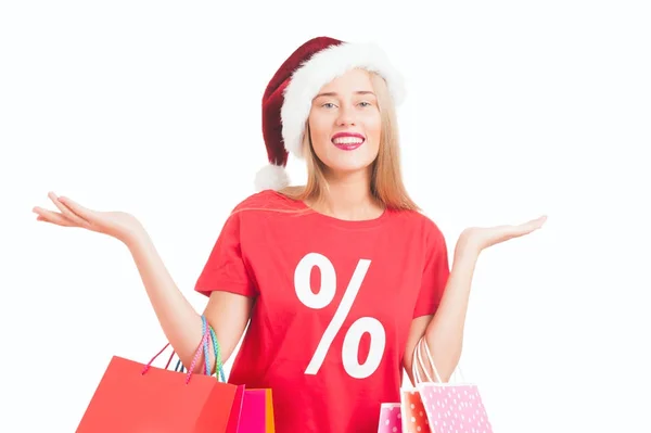 Jovem feliz com chapéu de santa carregando sacos de compras — Fotografia de Stock