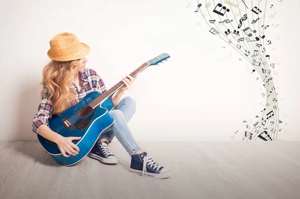 Young girl guitar play sitting on a floor