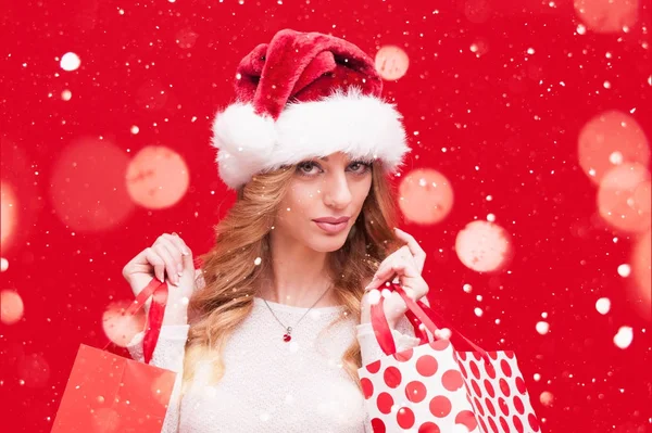 Weihnachtsfrau. blonde Modell Mädchen mit Weihnachtsmann Hut über rot — Stockfoto