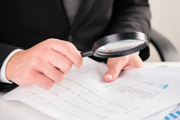 Hombre de negocios leyendo documentos con concepto de lupa para — Foto de Stock