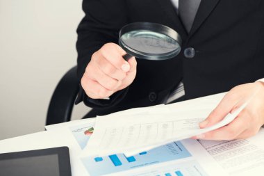 İşadamı için Büyüteç konseptiyle belgeleri okuma 