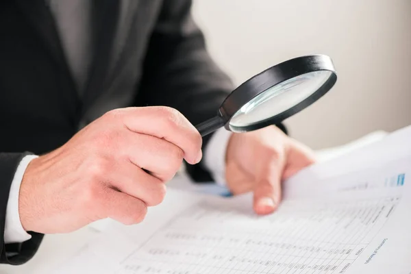 Hombre de negocios leyendo documentos con concepto de lupa para — Foto de Stock