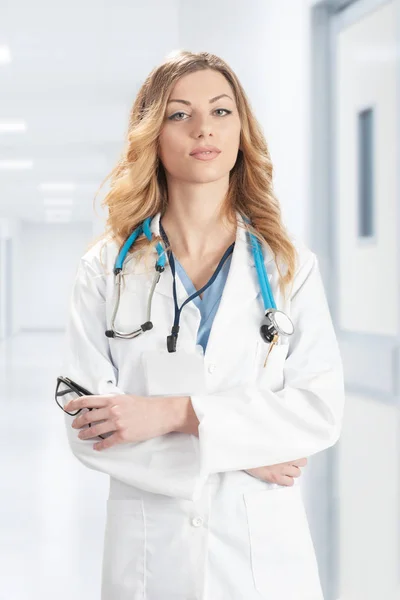 Γυναίκα γιατρό σε λευκό παλτό χειρουργική με στηθοσκόπιο στέκεται o — Φωτογραφία Αρχείου