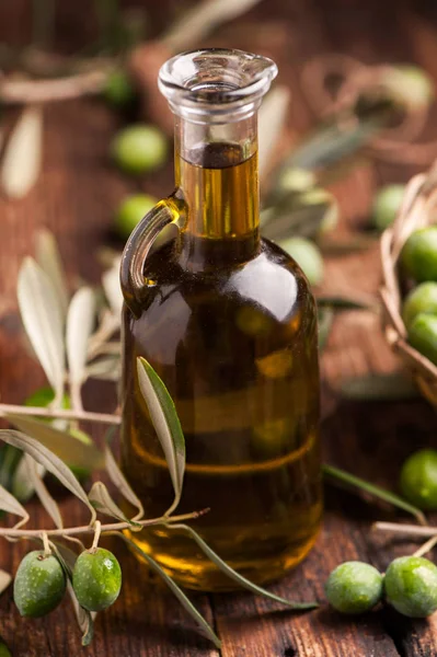 Butelki z oliwą z oliwek i olves na drewnianym stole — Zdjęcie stockowe