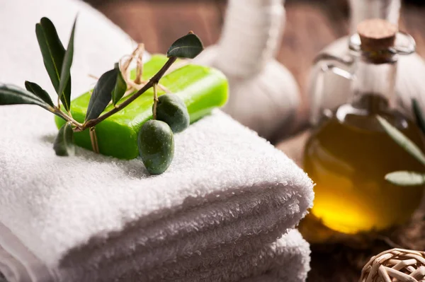 Olivenöl-Riegel-Seife mit Handtüchern auf Holzgrund — Stockfoto
