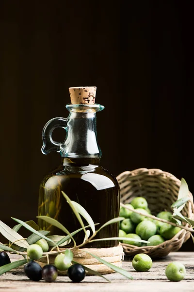 Bouteille d'huile d'olive et résout sur table en bois — Photo