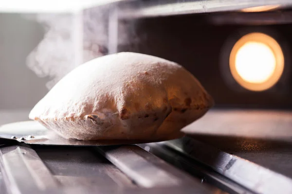 ピザのオーブンから出てくるイタリアのカルツォーネ — ストック写真