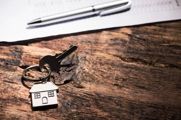 Klíč od domu na dřevěný stůl — Stock fotografie