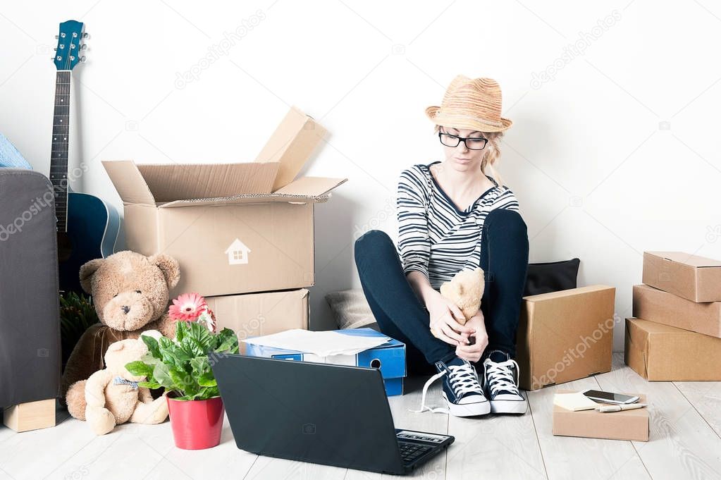 Moving house student girl sitting on the floor