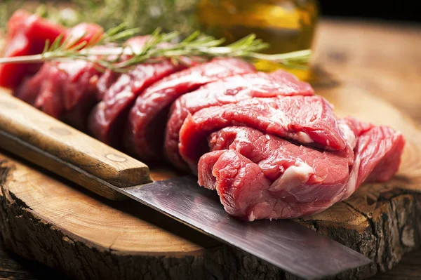 Carne crua fresca na velha mesa de madeira — Fotografia de Stock