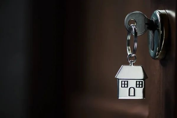 Silver house key in a door — Stock Photo, Image