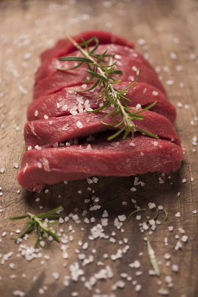 Bife cru em uma mesa de madeira escura. — Fotografia de Stock