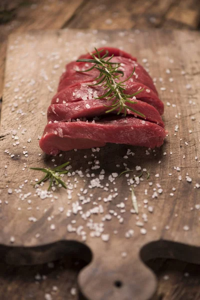 Bife cru em uma mesa de madeira escura. — Fotografia de Stock