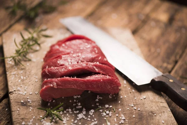 Syrový hovězí steak na tmavém dřevěném stole. — Stock fotografie