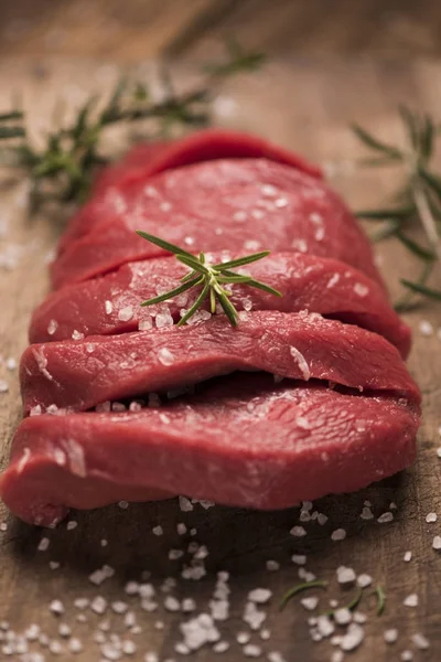 Bife cru em uma mesa de madeira escura. — Fotografia de Stock