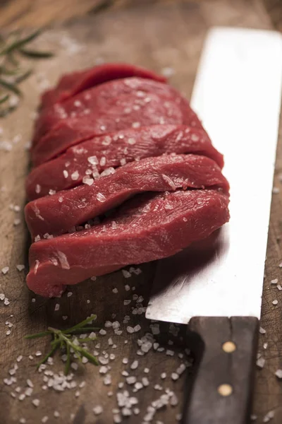 Raw beef steak on a dark wooden table. Stock Picture