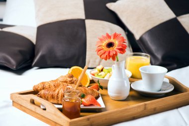 Bir yatak odası içinde yatakta kahvaltı yemek tepsisiyle