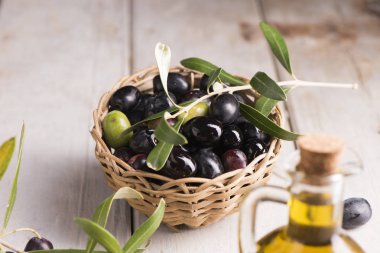 Zeytin ve zeytinyağı beyaz koyu ahşap masa üzerinde bir şişe