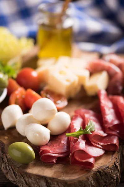 Carnes deli sortidas e um prato de queijo, em um corte de madeira b — Fotografia de Stock