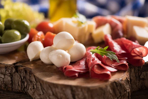 Carnes deli sortidas e um prato de queijo, em um corte de madeira b — Fotografia de Stock