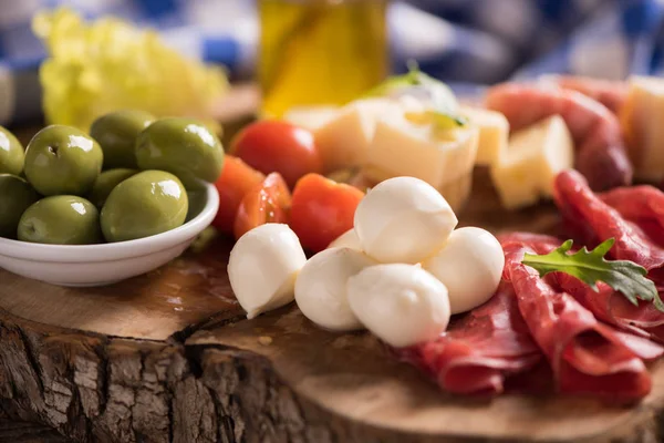 Carnes deli sortidas e um prato de queijo, em um corte de madeira b — Fotografia de Stock