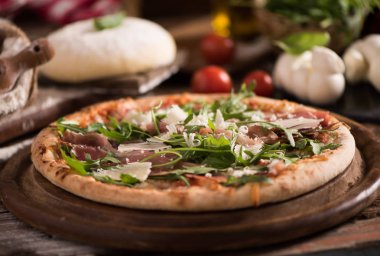 Ahşap masa üzerinde roket salata ile İtalyan Pizza