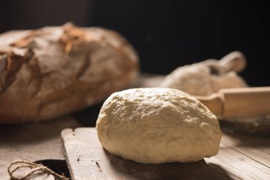 Koyu arka plan üzerinde ahşap masa üzerinde taze pişmiş ekmek