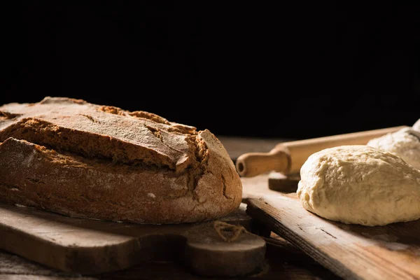 Pane appena sfornato su tavolo di legno su sfondo scuro — Foto Stock