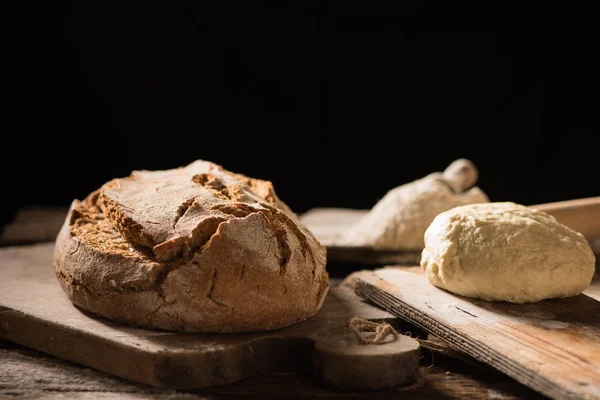 Pane appena sfornato su tavolo di legno su sfondo scuro — Foto Stock