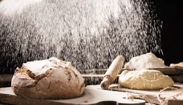 A fából készült asztal sötét háttér előtt flou a frissen sült kenyér — Stock Fotó