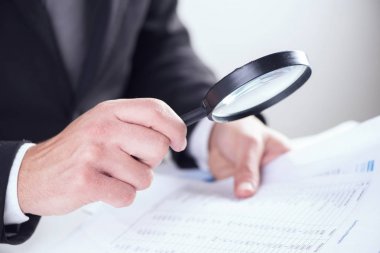 Büyüteç ile bir tablet kontrol işadamı 