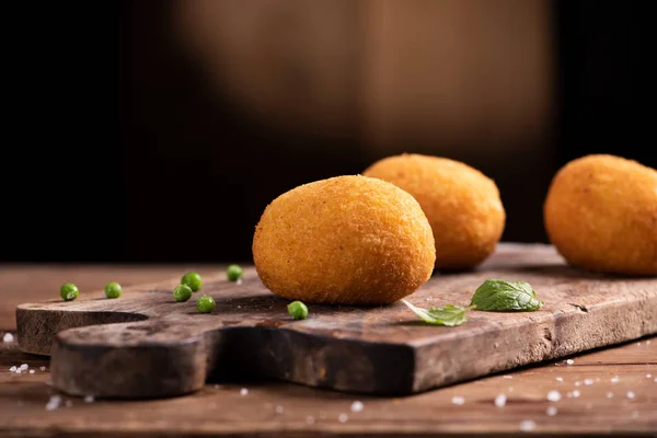 Bolas de arroz Arancini. Bolas de arroz frito sobre fondo de madera marrón —  Fotos de Stock