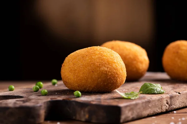 Arancini rice balls. Fried rice balls on brown wooden background — Stock Photo, Image